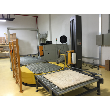 Unmanned pallet wrapping machine with powered conveyor